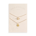 A pair of gold necklaces on a white card. The longer necklace features a honeycomb pendant, and the shorter necklace features a bee pendant. 