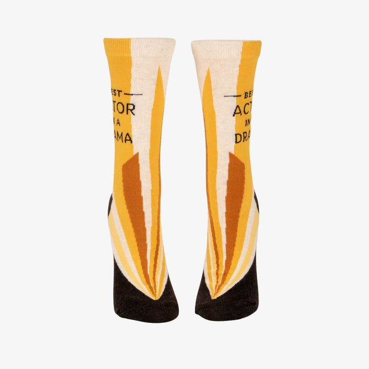 A pair of women's crew socks with a vibrant design of yellow and orange rays emanating from the bottom. Text on one sock reads 