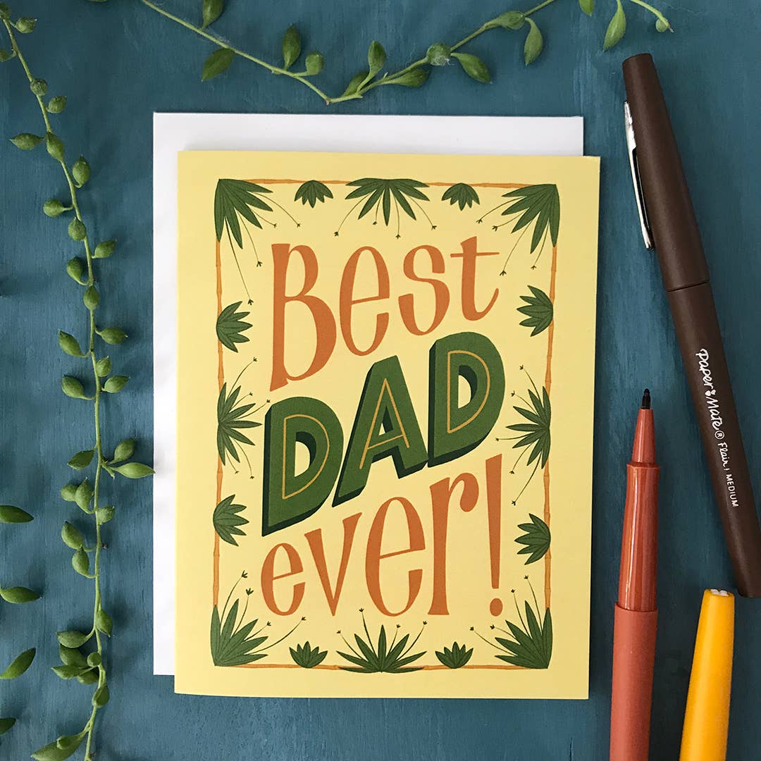 Greeting card with 'Best Dad Ever!' text on a blue background with pens and greenery.
