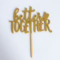 Gold 'better together' cake topper on a white background