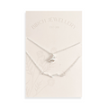 A pair of silver necklaces on a white card. The longer necklace features a branch pendant, and the shorter necklace features a bird pendant. 