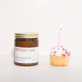 Jar of 'Birthday Cake' candle with a cupcake and candle on a white background