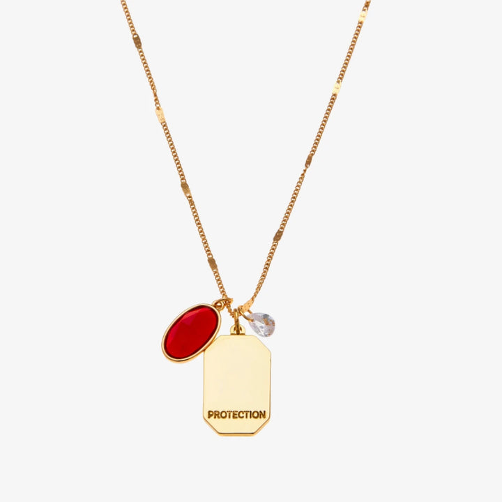 A gold necklace with a red garnet stone pendant. The pendant also has the word 