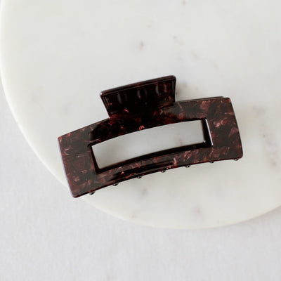 Brown hair clip on a white marble surface