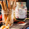 A glass jar filled with dried blueberries, mint leaves, and other ingredients. The jar has a white label with the Maiden Voyage logo and the product name 