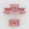 Two pink hair clamps on a white background