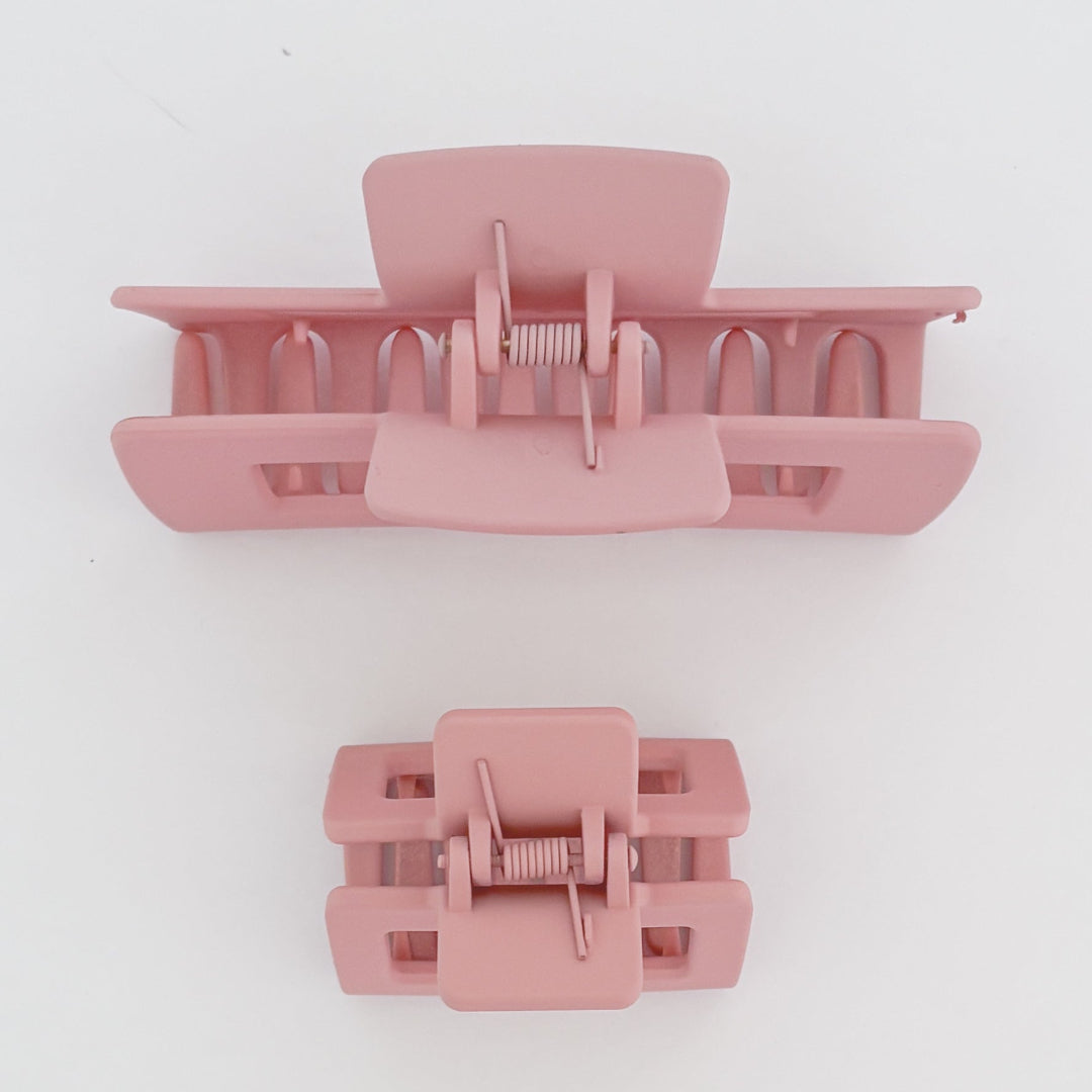 Two pink hair clamps on a white background