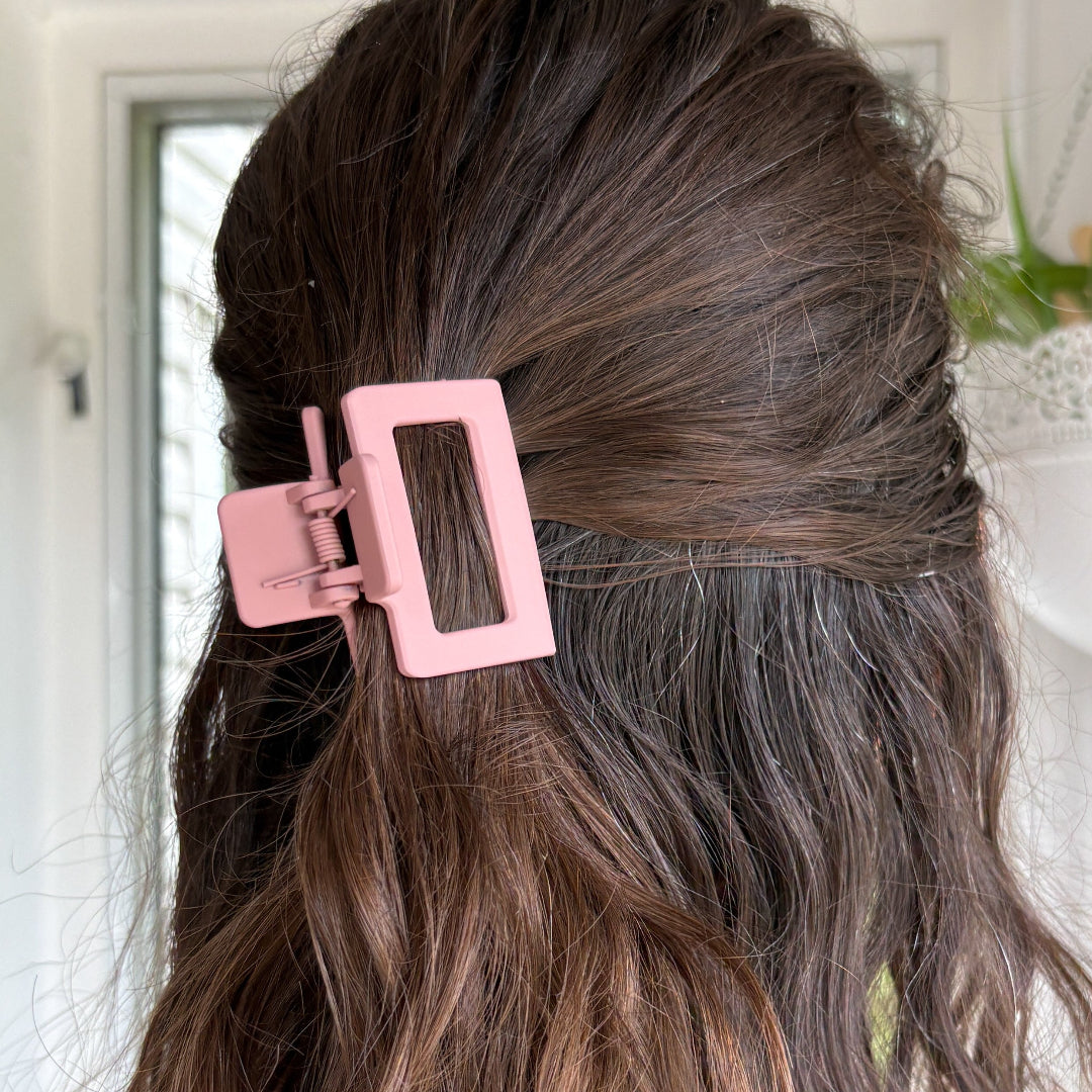 Pink hair clip in a person's hair with a blurred background