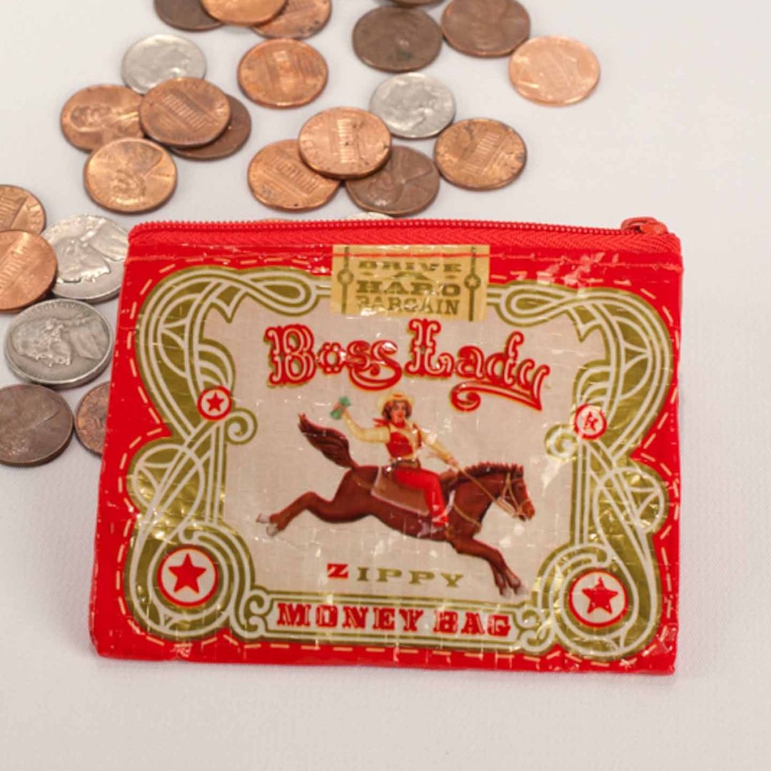 A small red coin purse with a zipper, featuring a vintage-style illustration of a woman riding a horse with a triumphant pose. The text "Boss Lady" is prominently displayed above her.
