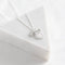 A silver plated necklace with a bow pendant.