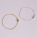 Gold and silver bracelets on a light gray background