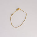 Gold bracelet on a light gray background