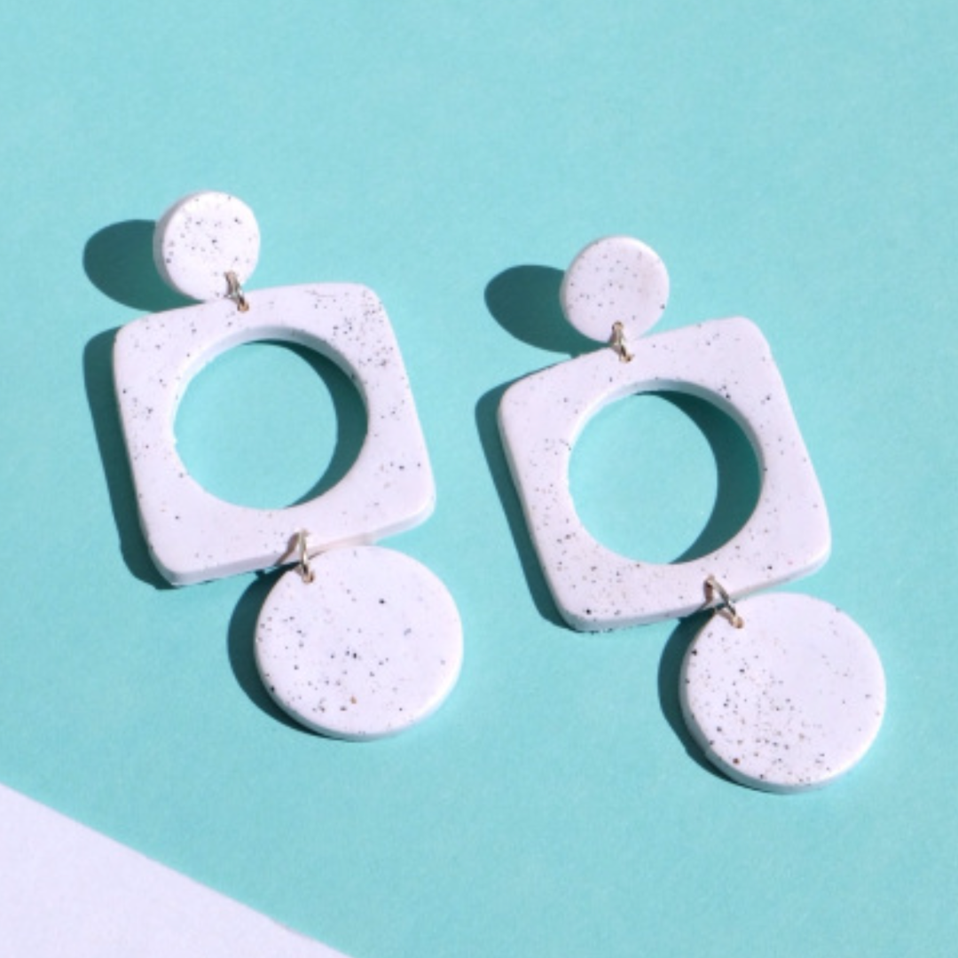 White concrete-style earrings on a light blue background