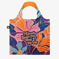 A colorful tote bag with a floral pattern and the text "I Usually Leave This Bag In The Car." The bag has a bright orange handle.