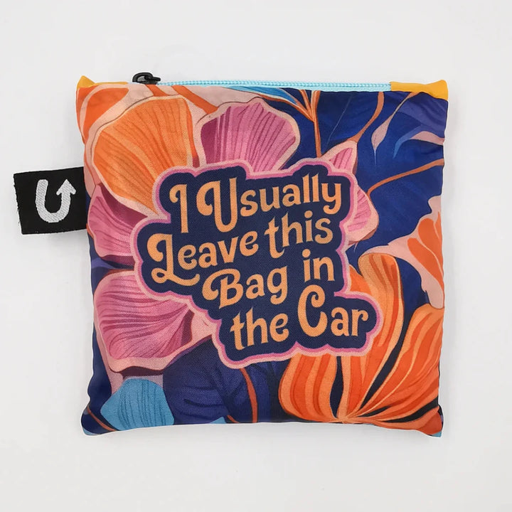 A colorful tote bag with a floral pattern and the text 