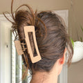 Person with hair styled in an updo using a beige hair clip.