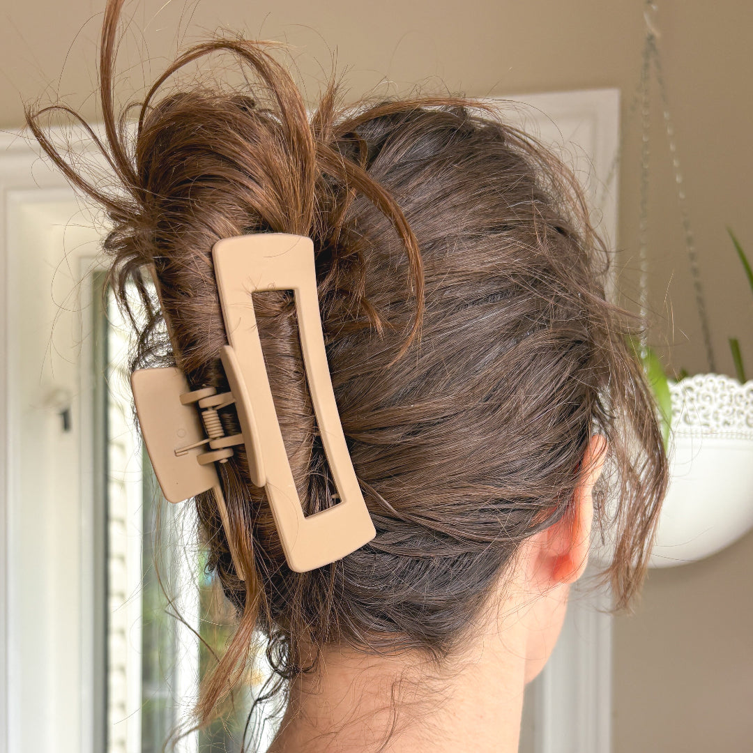 Person with hair styled in an updo using a beige hair clip.