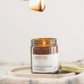Campfire scented candle jar with a wooden wick on a light background