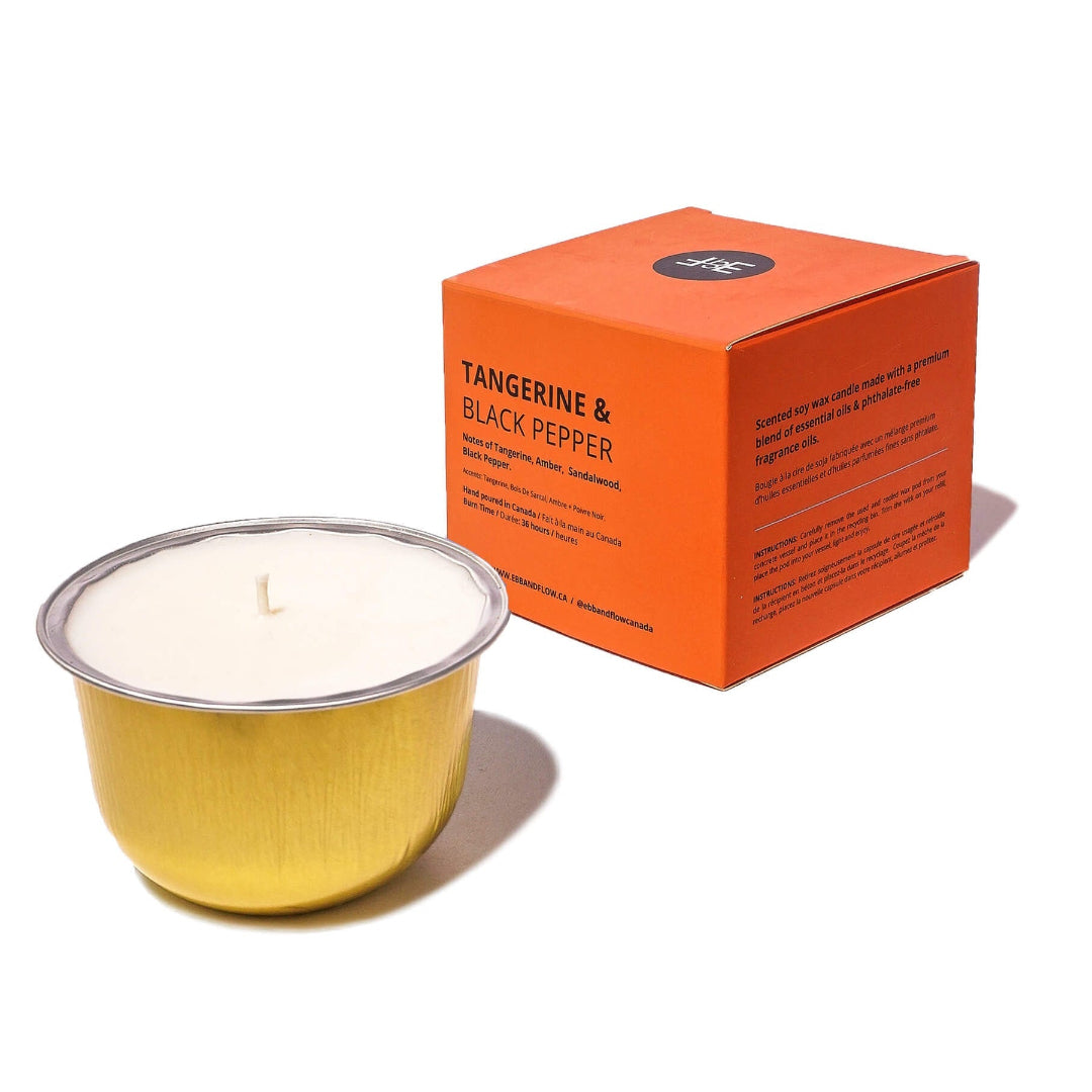 Candle with a gold container and an orange box labeled 'Tangerine & Black Pepper' on a white background