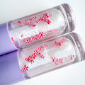 Lip gloss with candy cane design on a white background