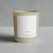 A beige glass jar candle with a white label. The label reads 