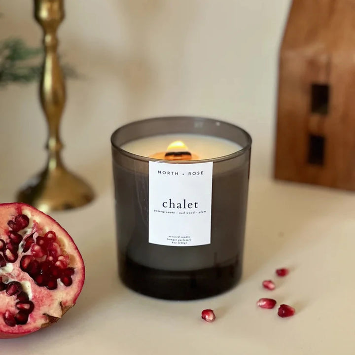 A black glass jar candle with a white label. The label reads 
