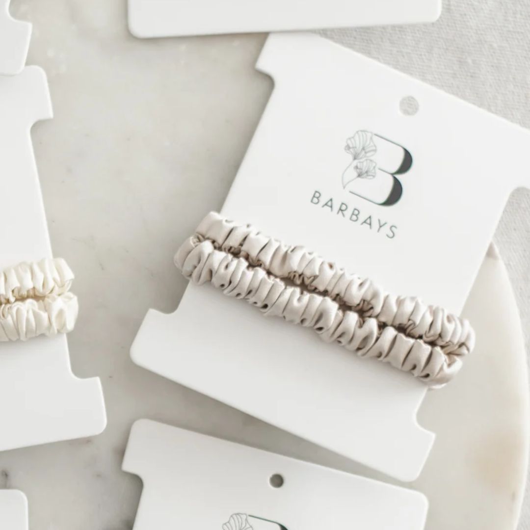Barbays hair ties on white cards with a neutral background