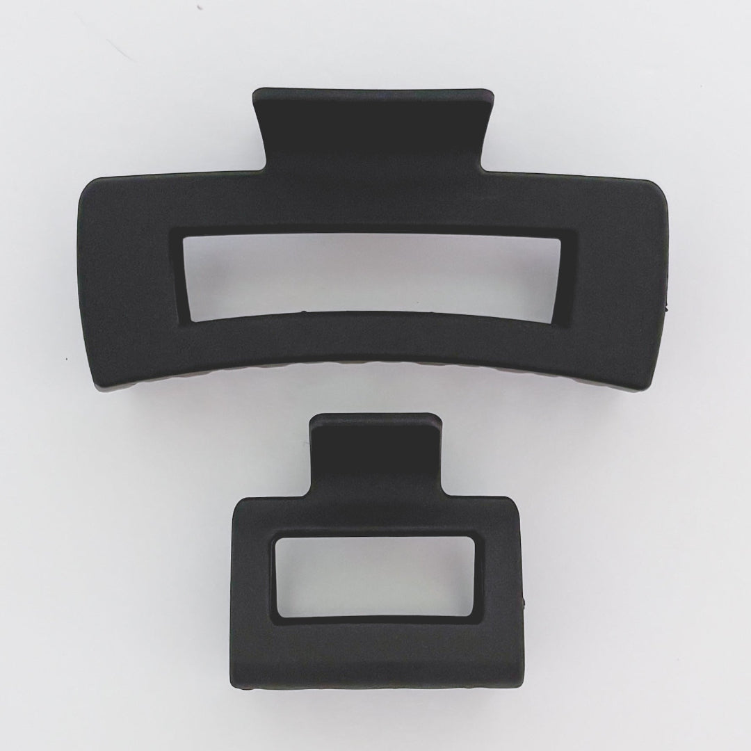 Two black hair clips on a white background