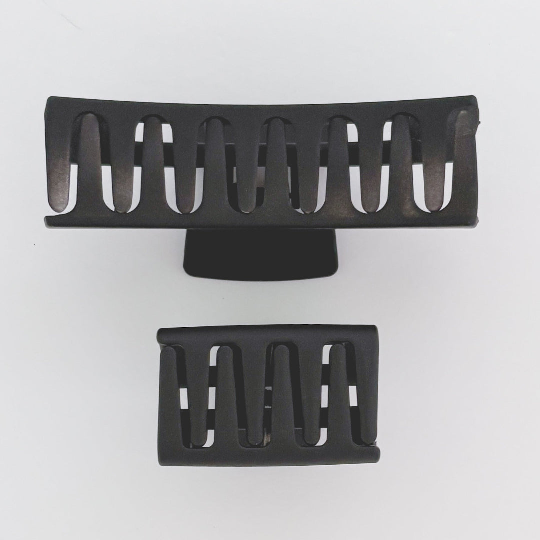 Two black hair clips on a white background