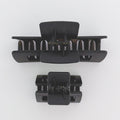 Two black hair clamps on a white background
