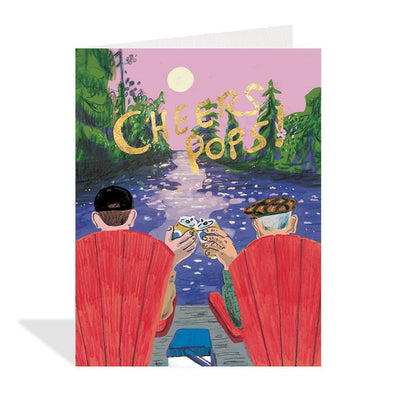 White greeting card featuring an illustration by Canadian artist Tine Modeweg-Hansen of two men sitting in red chairs by a lake at sunset, holding up beer cans. The text 