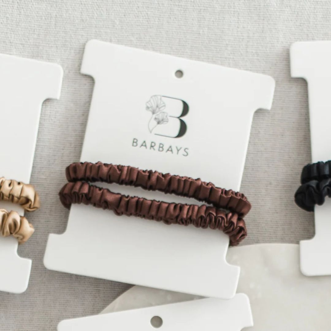 Brown hair tie on a Barbays branded card with gold and black hair ties on the side.