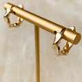 Gold earrings on a beige background