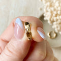 Gold ring on a hand with a blurred background of flowers