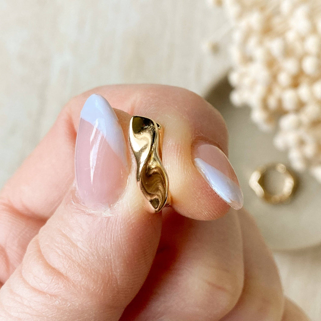 Gold ring on a hand with a blurred background of flowers