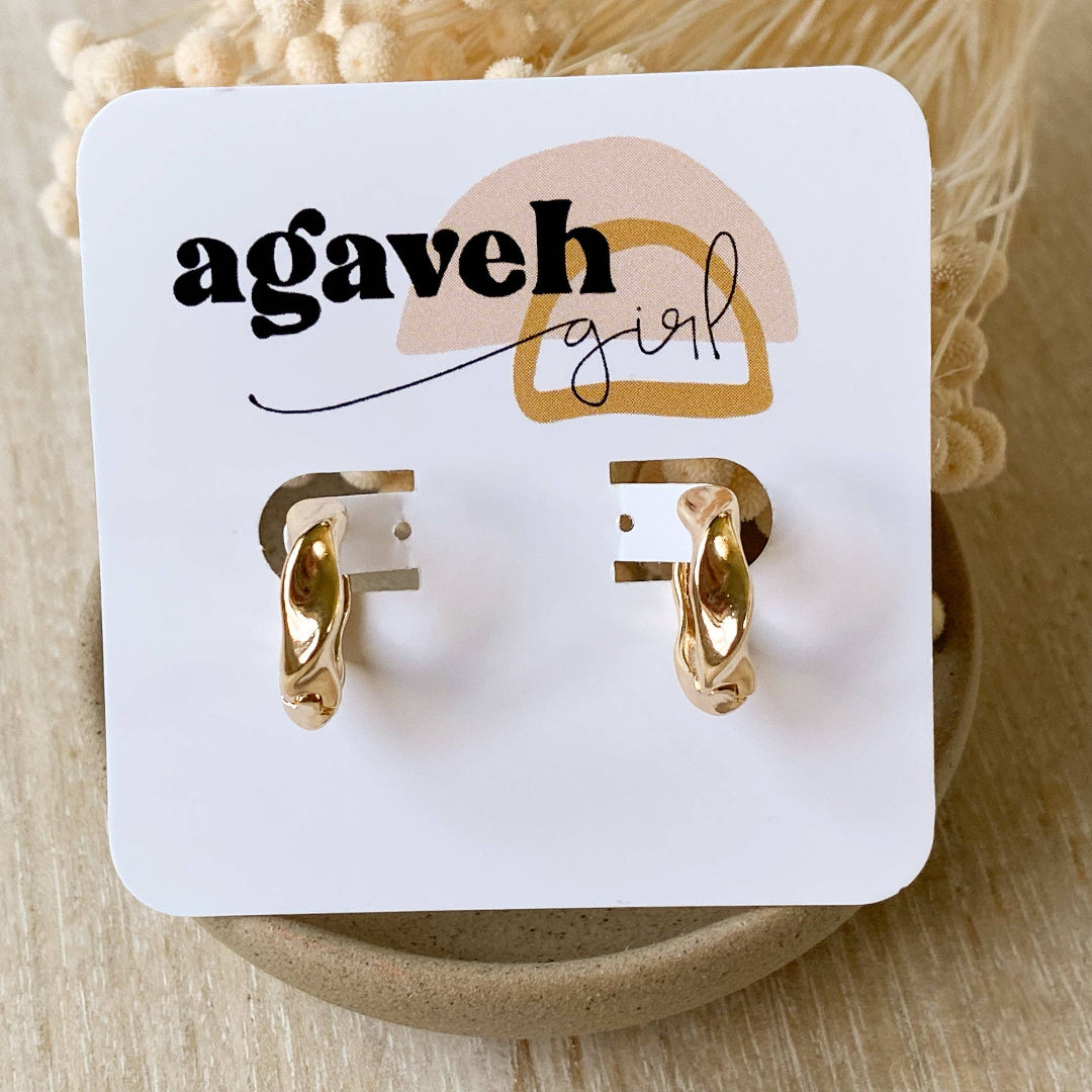 Gold hoop earrings on a 'agaveh girl' branded card with beige background