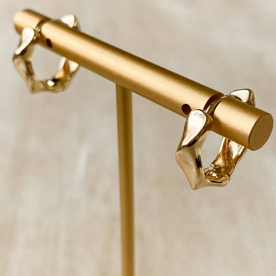 Gold earrings on a beige background