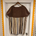 Brown and patterned dress on a hanger against a white door with decorative orange border.