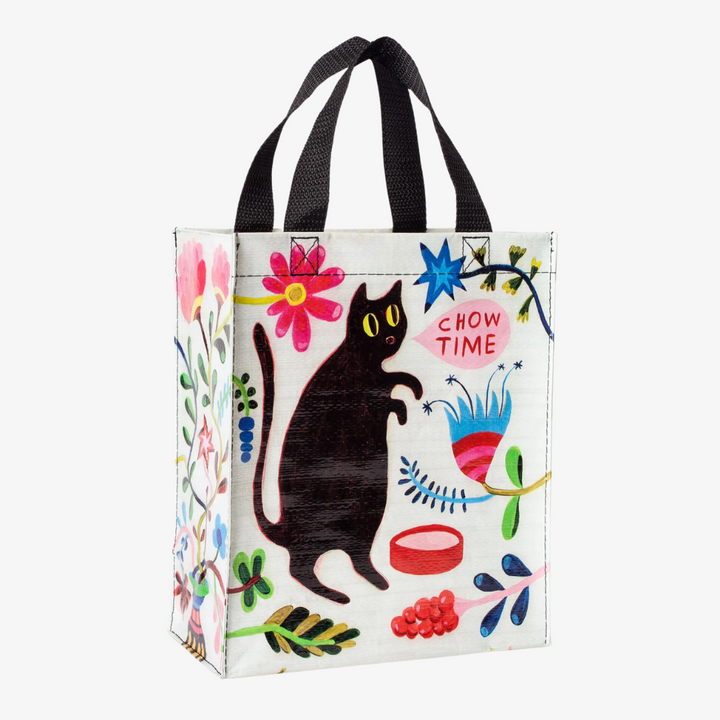 A reusable tote bag with a playful cat design. The bag is white with a black cat standing on its hind legs near a bowl of food. The text 
