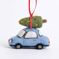 Felted ornament of a blue car carrying a Christmas tree on a white background