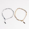 Two chain necklaces, one silver and one gold, on a white background