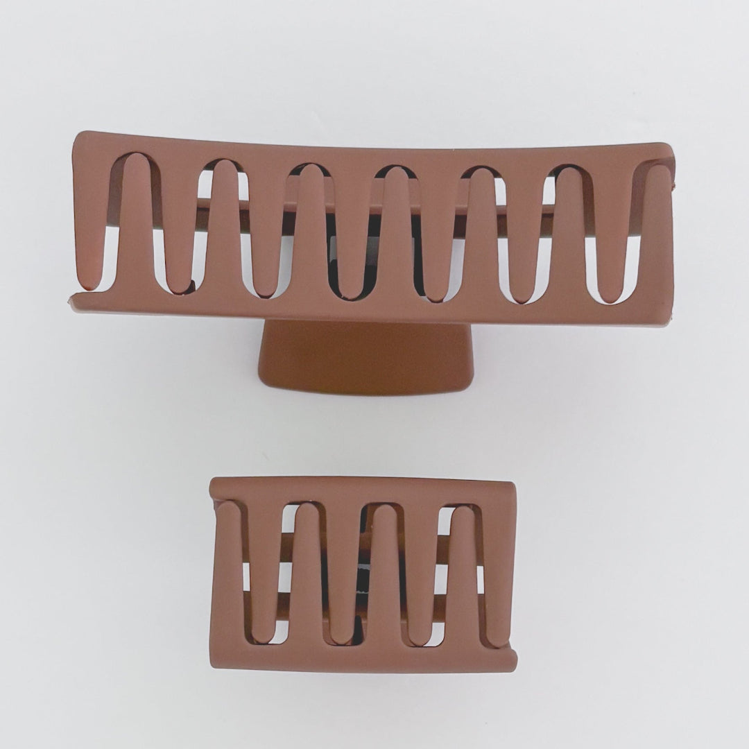 Two brown hair clips on a white background