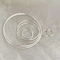 A set of classic hoop earrings made of 925 sterling silver, featuring various sizes of thin, polished silver hoops, displayed on a brown and textured surface. These simple and elegant earrings are available in Ottawa, Ontario, Canada.