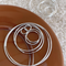 A set of classic hoop earrings made of 925 sterling silver, featuring various sizes of thin, polished silver hoops, displayed on a brown and textured surface. These simple and elegant earrings are available in Ottawa, Ontario, Canada.