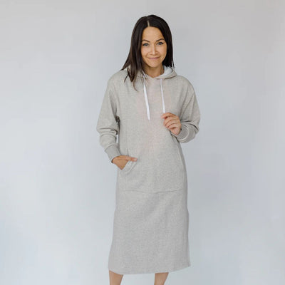 Woman wearing a gray hoodie dress against a white background