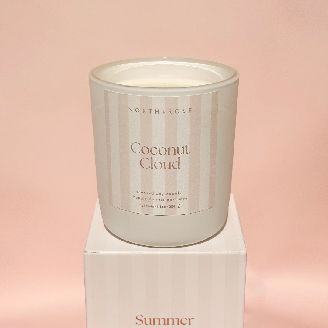 Candle labeled 'Coconut Cloud' by North Rose on a pink background