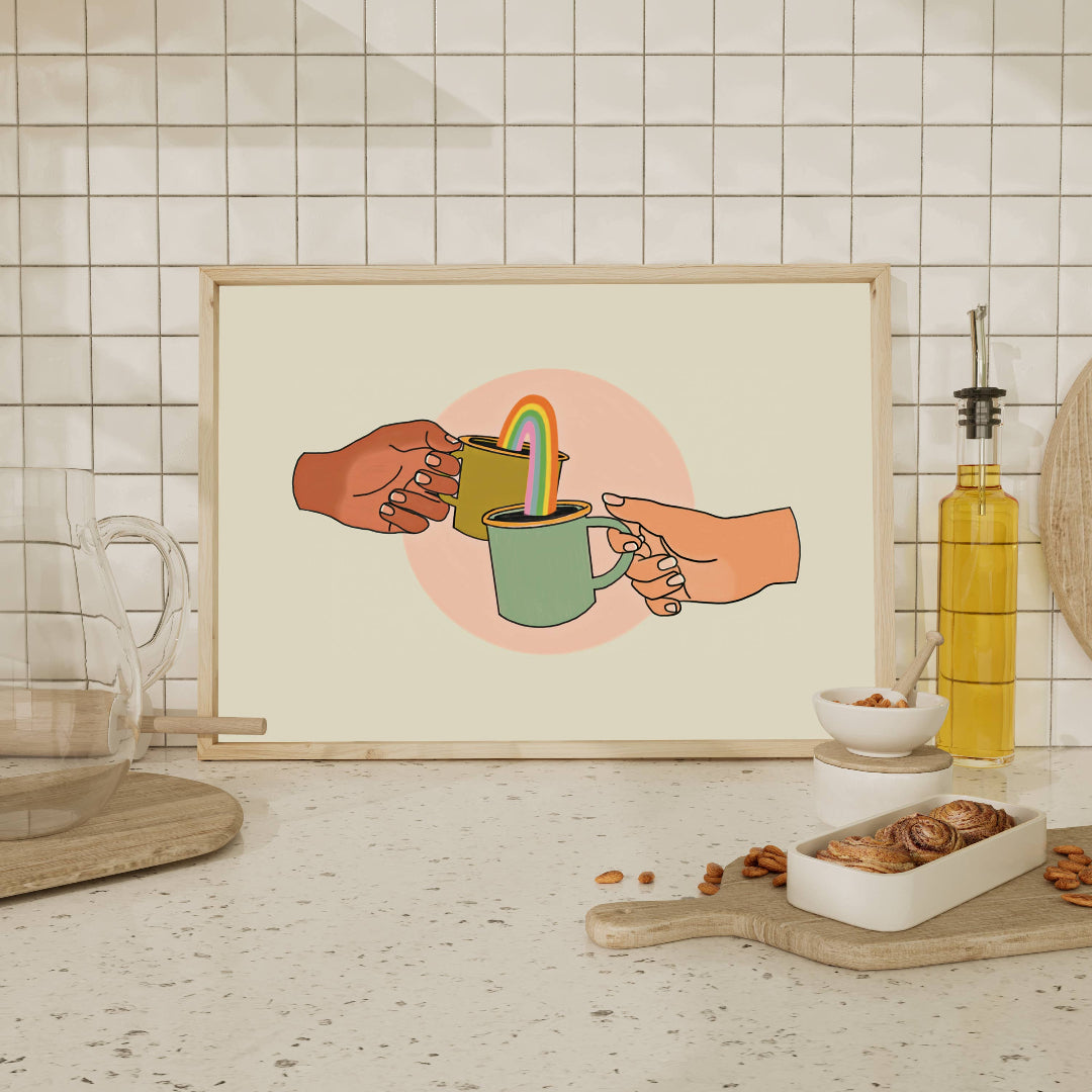 Framed artwork of two hands sharing a rainbow-colored cup on a kitchen counter.