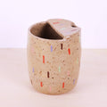Ceramic cup with colorful speckles on a white background