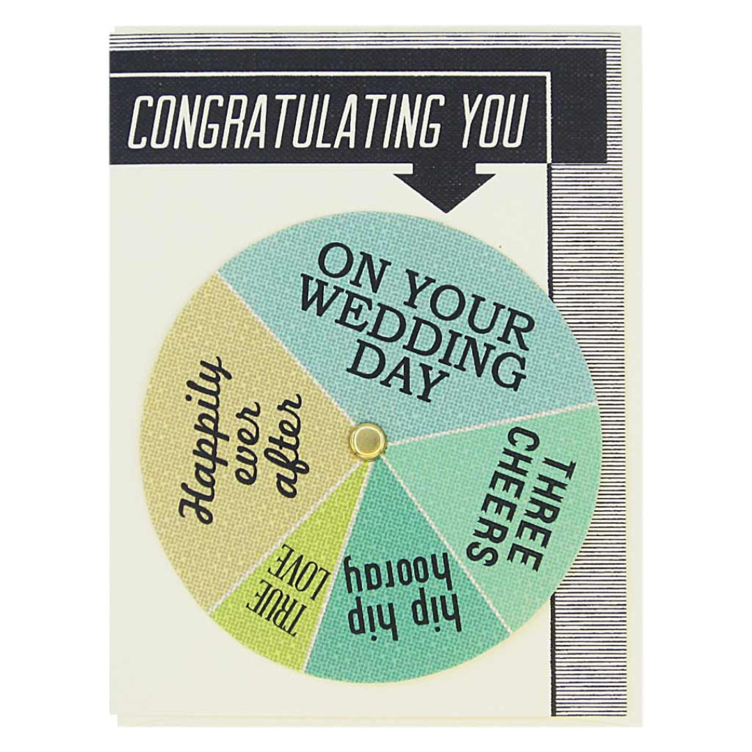 A wedding congratulations card with a black border at the top and bottom. The top border has white text that says "CONGRATULATING YOU". Below this, there is a circular spinner with various wedding sentiments. The spinner has a gold brad in the center. The sentiments visible on the spinner include "ON YOUR WEDDING DAY", "THREE CHEERS", "Hip hip hooray", "TRUE LOVE", and "Happily ever after".