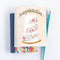 A congratulations card featuring a three-tiered wedding cake decorated with colorful flowers. The word 